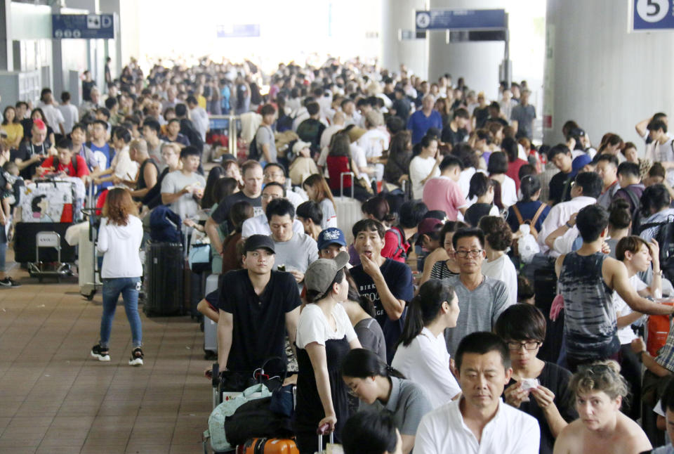 Stranded passengers queue up in lines to wait for special buses