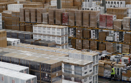 A worker walks amongst white goods at the PC World and Carphone Warehouse distribution centre in Newark, Britain November 21, 2017. REUTERS/Darren Staples