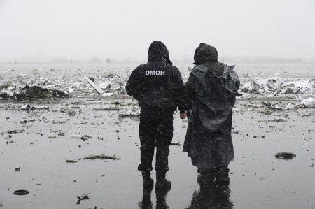 An officer of the special police force (L) stands guard at the crash site of Flight FZ981, a Boeing 737-800 operated by Dubai-based budget carrier Flydubai, at the airport of Rostov-On-Don, Russia, March 19, 2016. REUTERS/Stringer