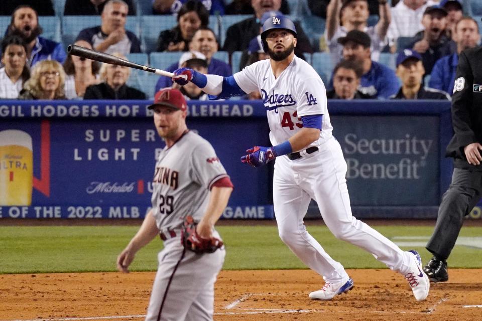 Los Angeles Dodgers' Edwin Rios, right, heads to first as he hits a three-run home run while Arizona Diamondbacks starting pitcher Merrill Kelly watches during the second inning of a baseball game Tuesday, May 17, 2022, in Los Angeles.