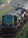 <p>Sri Lankan passengers hold onto the outside of a trian carriage as they travel during a nationwide rail strike in Colombo on December 13, 2017. Hundreds of thousands of pupils were left stranded on December 12 after railway workers in Sri Lanka refused to abandon a strike during national exams. (Photo by ISHARA S. KODIKARA/AFP/Getty Images) </p>