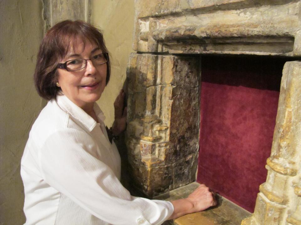 This June 21, 2012 photo shows chapel guide Patricia Goodson-Ra?mirez resting her hand on the stone said to have been kissed by Joan of Arc, at the St. Joan of Arc Chapel in Milwaukee. The chapel was donated to Marquette University in the 1960s, after being in France for more than 500 years. (AP Photo/Carr?ie Antlfinger?)