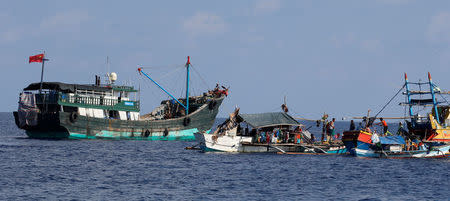 A Chinese fishing vessel is anchored next to Filipino fishing boats at the disputed Scarborough Shoal April 6, 2017. Picture taken April 6, 2017 REUTERS/Erik De Castro