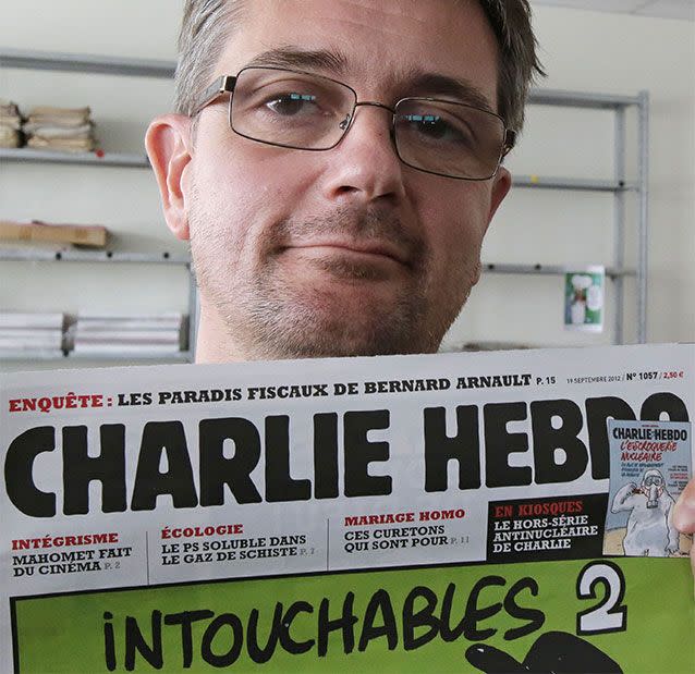 Stephane Charbonnier also known as Charb, the editor of the satirical weekly Charlie Hebdo, displays the front page of the newspaper as he poses for photographers in Paris. Photo: AP