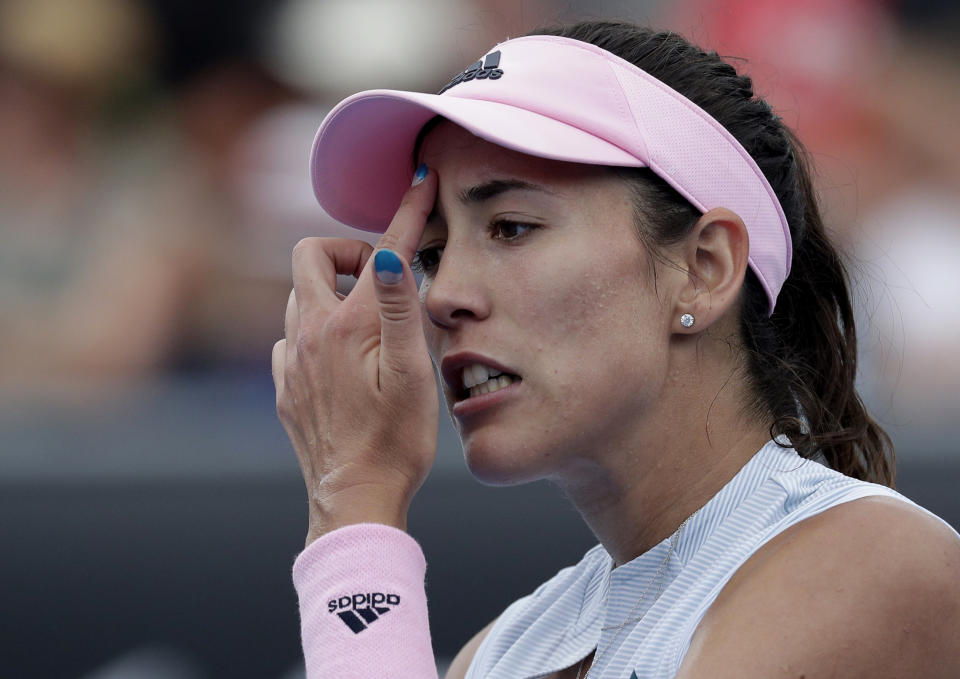 Spain's Garbine Muguruza wipes sweat from her face during her first round match against China's Zheng Saisai at the Australian Open tennis championships in Melbourne, Australia, Tuesday, Jan. 15, 2019. (AP Photo/Kin Cheung)