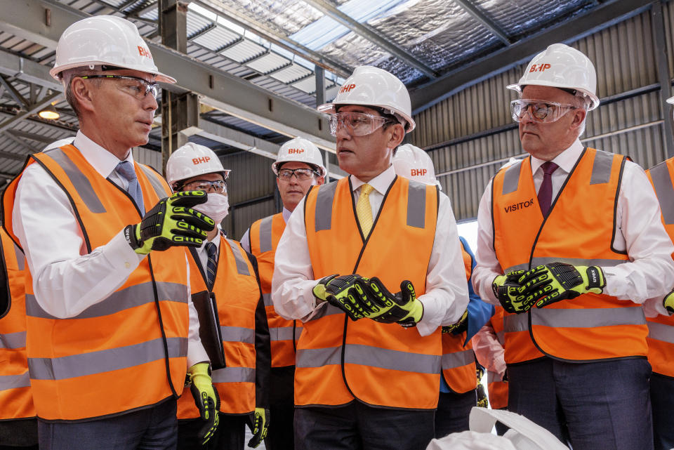 Mike Henry, left, CEO of BHP shows nickel briquettes to Japan's Prime Minister Fumio Kishida, center, and Australian Prime Minister Anthony Albanese, right, at the BHP Nickel West Kwinana Nickel Refinery near Perth, Australia, Saturday, Oct. 22, 2022. Kishida is on a visit to bolster military and energy cooperation between Australia and Japan amid their shared concerns about China. (Richard Wainwright/Pool Photo via AP)
