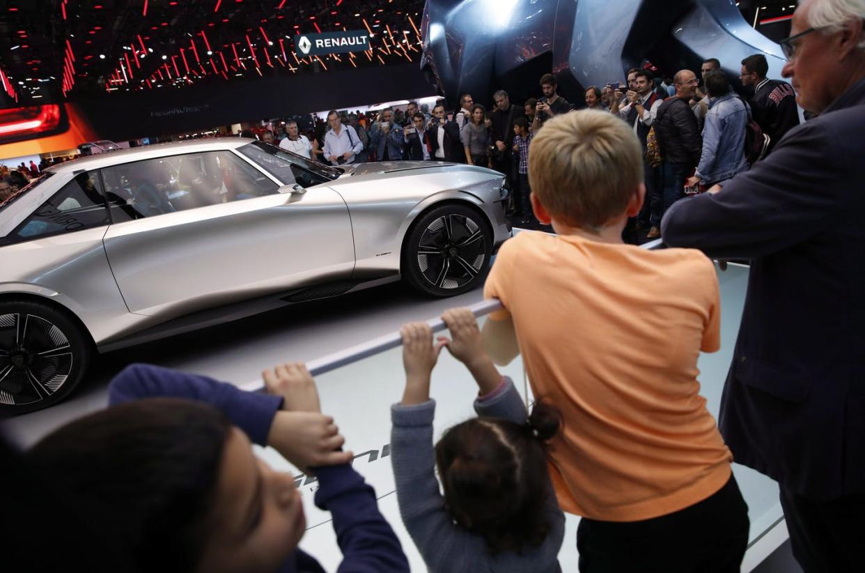 <span class="caption">Visitors look at a Peugeot E Legend concept car on display at the Auto show in Paris, France, in 2018, where all-electric vehicles were among the stars of the show. </span> <span class="attribution"><span class="source">(AP Photo/Christophe Ena) </span></span>