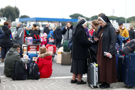 Passengers who were evacuated due to a fire at Ciampino Airport in Rome, Italy, February 19, 2019 gather outside the teminal building. REUTERS/Yara Nardi