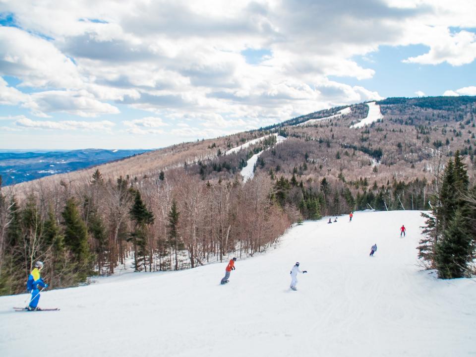 People skiing and snowboarding at Ski Resort Mountain in Vermont.