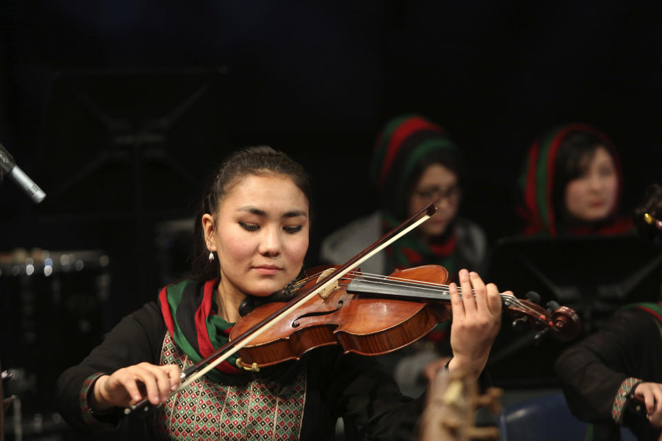 In this Wednesday, Feb. 15, 2017 photo, Zarifa Adiba, 18, an orchestra conductor in Afghanistan, plays during a concert in Kabul. Afghanistan’s first all-female symphony is trying to change attitudes in a deeply conservative country where many see music as immoral, especially for women. (AP Photo/Rahmat Gul)