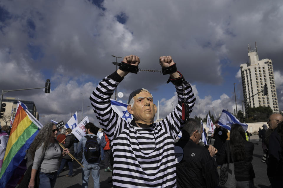 FILE - A protester wearing a rubber mask depicting Israeli Prime Minister Benjamin Netanyahu demonstrates in front of the Supreme Court in Jerusalem against the appointment of Aryeh Deri, the leader of the ultra-Orthodox Shas party as the country's new health minister, Thursday, Jan, 5, 2023. (AP Photo/Mahmoud Illean, File)