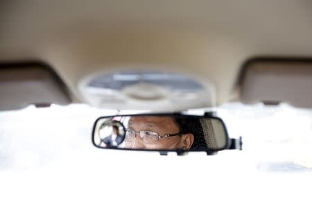 Ri Yong Chol, a taxi driver for Korea Kumgang Group (KKG), is reflected in a rearview mirror of his vehicle as he ferries passengers in central Pyongyang, North Korea October 8, 2015. REUTERS/Damir Sagolj