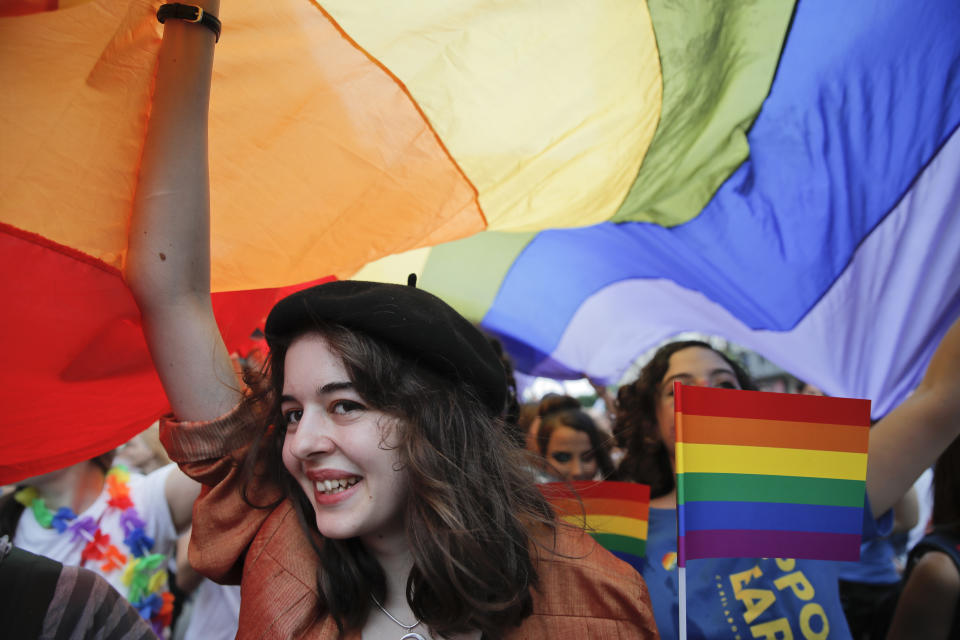 <p>A girl smiles under a large rainbow flag during the gay pride parade in Bucharest, Romania, Saturday, June 9, 2018. People taking part in the gay pride parade in the Romanian capital demanded more rights and acceptance for same-sex couples. (Photo: Vadim Ghirda/AP) </p>