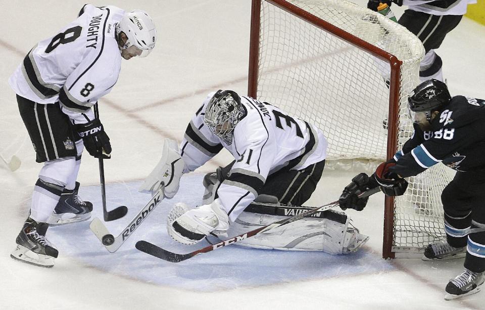 Los Angeles Kings goalie Martin Jones, center, blocks a shot during the third period of Game 1 of an NHL hockey first-round playoff series against the San Jose Sharks Thursday, April 17, 2014, in San Jose, Calif. At left is Kings' Drew Doughty (8), at right Sharks' Brent Burns. (AP Photo/Ben Margot)