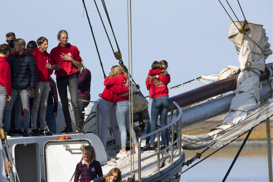 Students hug as their schooner carrying 25 Dutch teens who sailed home from the Caribbean across the Atlantic when coronavirus lockdowns prevented them flying arrives at the port of Harlingen, northern Netherlands, Sunday, April 26, 2020. (AP Photo/Peter Dejong)