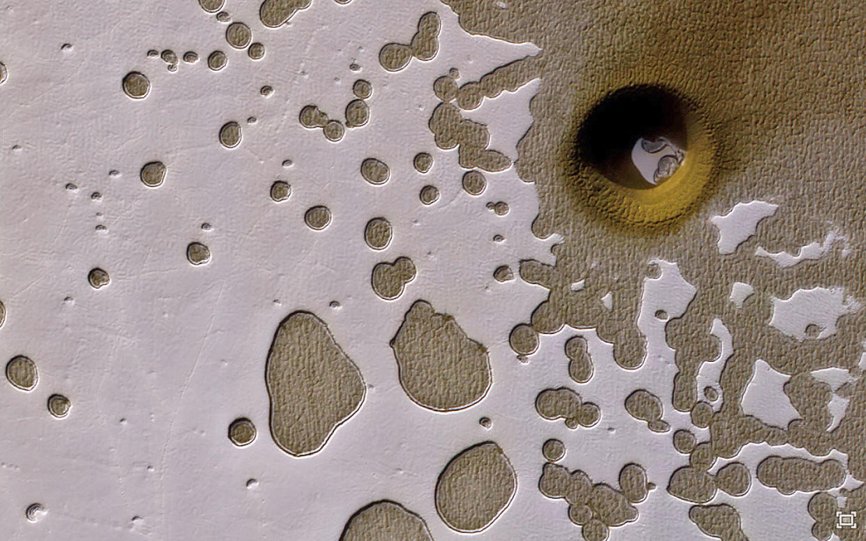 This strange, nearly perfectly circular feature in&nbsp;a &ldquo;Swiss Cheese&rdquo; area of Mars has scientists wondering if it was formed from something that fell from the sky, or if it resulted from a ground collapse. (Photo: NASA/JPL-Caltech/Univ of Arizona)