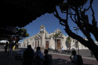 In this Feb. 10, 2020 photo, people walk past "Casa de los Perros," or "House of the Dogs," in central Apaseo El Grande, Guanajuato state, Mexico. In 2019, the state had a murder rate of about 61 per 100,000 inhabitants, making it Mexico's most violent. (AP Photo/Rebecca Blackwell)