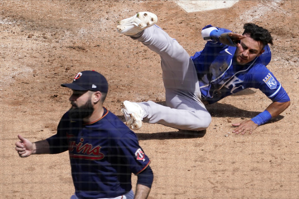 Kansas City Royals' Nicky Lopez topples in the dirt after scoring on one of two errors against the Minnesota Twins in the fourth inning of a baseball game, Saturday, May 1, 2021, in Minneapolis. At left is Twins pitcher Matt Shoemaker. (AP Photo/Jim Mone)