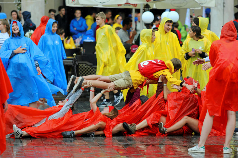 <p>Pilgrims covered in rain coats play during heavy rain on World Youth Day at the Main Square in Krakow, Poland July 26, 2016. (Agencja Gazeta/Mateusz Skwarczek/via REUTERS)</p>