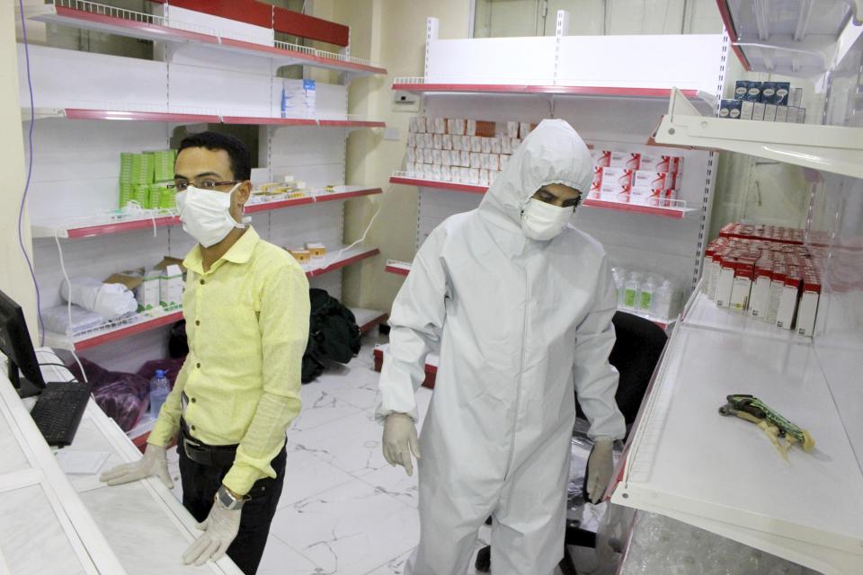 In this May 12, 2020 photo, Yemeni medical workers wearing masks and protective gear stand at the entrance of a hospital in Aden, Yemen. People have been dying by the dozens each day in southern Yemen's main city, Aden, many of them with breathing difficulties, say city officials. Blinded with little capacity to test, health workers fear the coronavirus is running out of control, feeding off a civil war that has completely broken down the country. (AP Photo/Wail al-Qubaty)