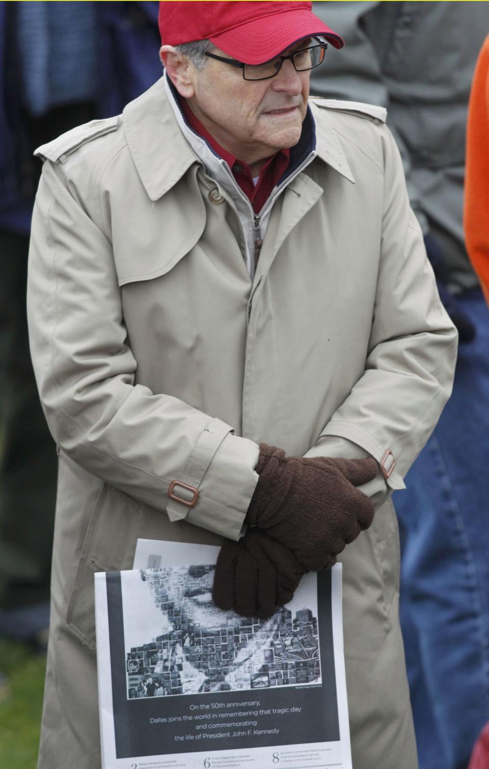 Spectator holds special section of newspaper commemorating the 50th anniversary of JFK's assassination in Dallas