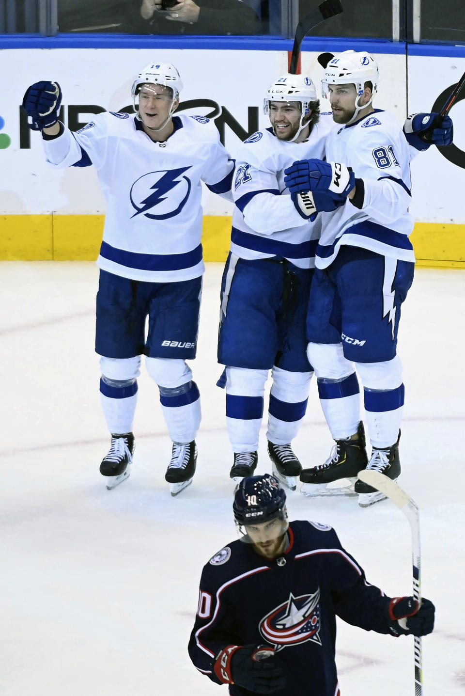 Tampa Bay Lightning center Brayden Point (21) celebrates his goal with teammates Barclay Goodrow (19) and Erik Cernak (81) as Columbus Blue Jackets center Alexander Wennberg (10) skates away during the second period of an NHL Eastern Conference Stanley Cup hockey playoff game in Toronto, Saturday, Aug. 15, 2020. (Nathan Denette/The Canadian Press via AP)