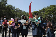 Graduate students pause during a makeshift memorial for Chow Tsz-Lok at the University of Science and Technology in Hong Kong on Friday, Nov. 8, 2019. A graduation ceremony was cut short, and black-clad masked students turned the stage into a memorial for Chow who fell off a parking garage after police fired tear gas during clashes with anti-government protesters and died Friday. (AP Photo/Kin Cheung)