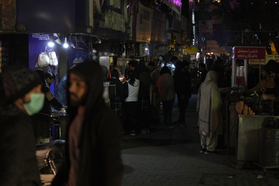 People visit a market, where some shopkeeper are using generators for electricity during a national-wide power breakdown, in Islamabad, Pakistan, Monday, Jan. 23, 2023. Much of Pakistan was left without power Monday as an energy-saving measure by the government backfired. The outage spread panic and raised questions about the cash-strapped government's handling of the country's economic crisis. (AP Photo/Anjum Naveed)