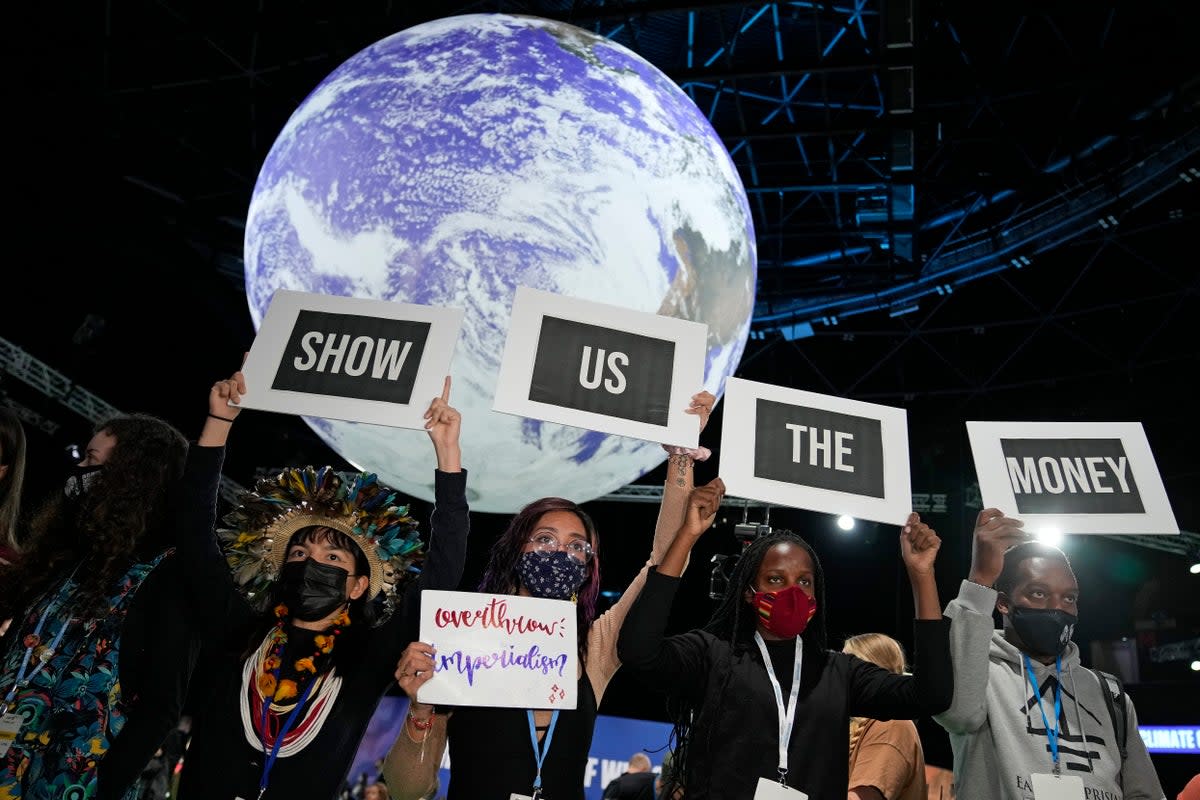 Climate protesters hold up signs at the UN  (Copyright 2021 The Associated Press. All rights reserved)