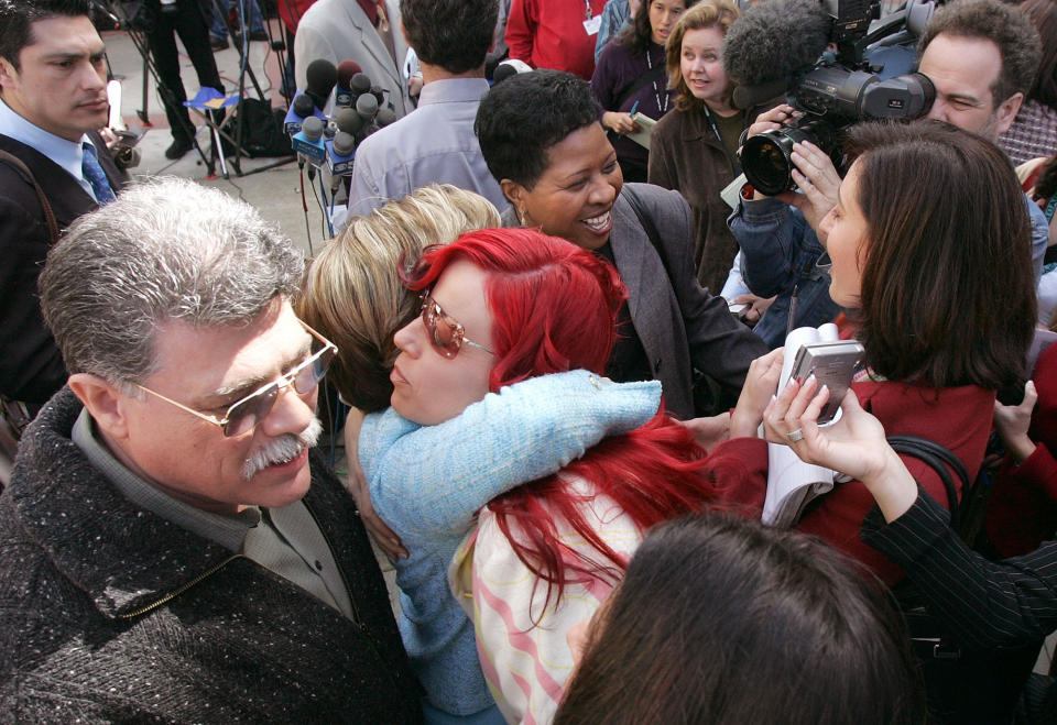 FILE - Juror Richelle Nice, center, hugs attorney Gloria Allred after speaking at a news conference after the formal sentencing of Scott Peterson in Redwood City, Calif., on March 16, 2005. Nice, a former juror who helped convict Scott Peterson and send him to death row, is expected to testify under a grant of immunity as she kicks off a weeklong hearing starting Friday, Feb. 25, 2022, centered on whether she lied about her history with domestic violence. (AP Photo/Jeff Chiu, File)