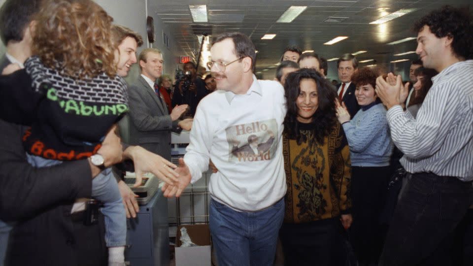 Wearing a sweatshirt printed with his picture, former hostage Terry Anderson greets happy colleagues, on Dec. 10, 1991, at The Associated Press headquarters in New York, as he walks with his arm around fiancee Madeleine Bassil. - Mark Lennihan/AP