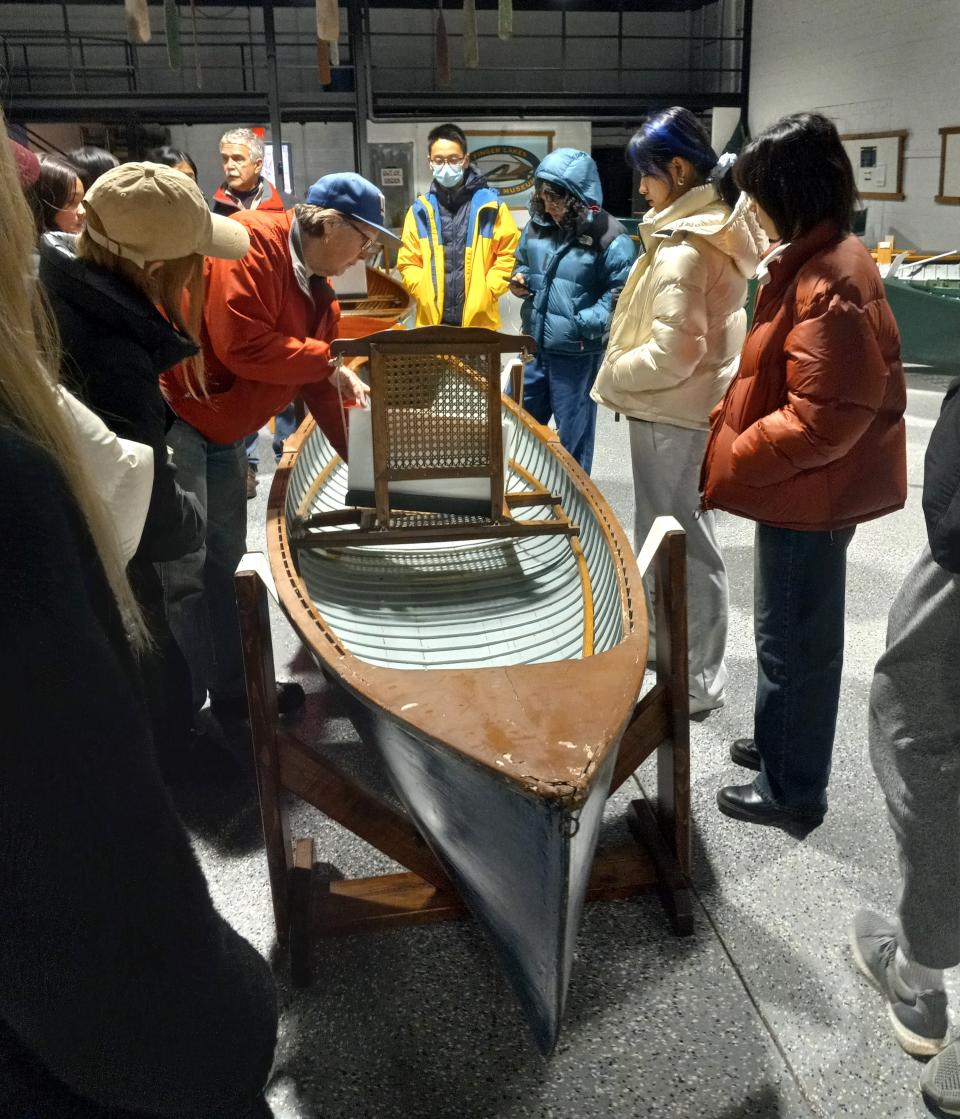 Finger Lakes Boating Museum exhibit specialist Beth Lucek shows Cornell University students one of the watercrafts in the museum's collection.