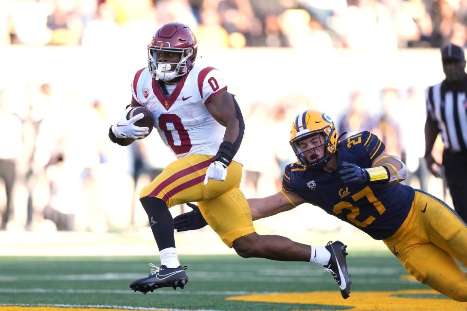 Oct 28, 2023; Berkeley, California, USA; USC Trojans running back MarShawn Lloyd (0) carries the ball against California Golden Bears linebacker Cade Uluave (27) during the fourth quarter at California Memorial Stadium. Mandatory Credit: Darren Yamashita-USA TODAY Sports