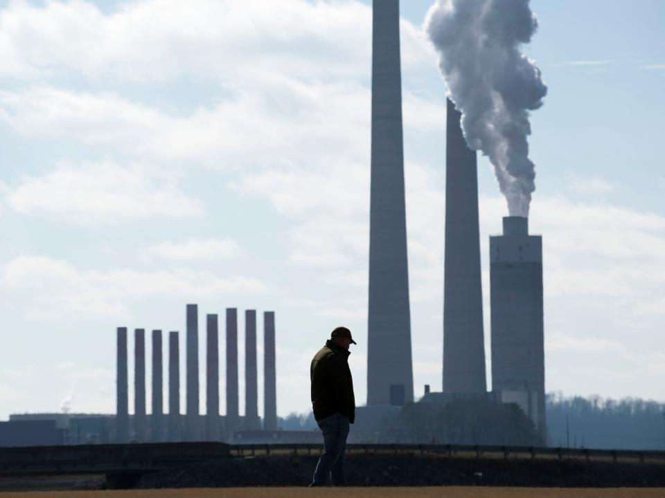 A former coal ash cleanup worker stands before the Kingston Fossil Plant in Roane County.