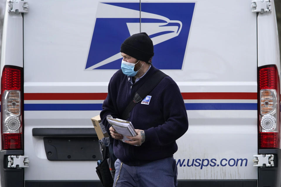 Postal carrier Josiah Morse heads out to deliver mail and packages, Wednesday, Feb. 3, 2021, in Portland, Maine. The U.S. Postal Service's stretch of challenges didn't end with the November general election and tens of millions of mail-in votes. The pandemic-depleted workforce fell further into a hole during the holiday rush, leading to long hours and a mountain of delayed mail. (AP Photo/Robert F. Bukaty)