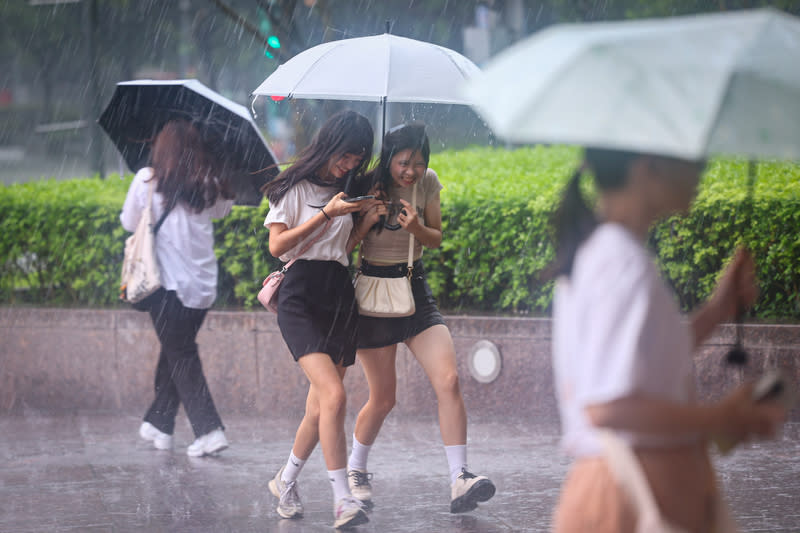 台北午後大雷雨（1） 中央氣象署28日下午發布新北市、台北市、桃園市等 10縣市大雨特報。圖為台北市信義區午後下起大雷 雨，民眾撐傘快步躲雨。 中央社記者王騰毅攝  113年6月28日 