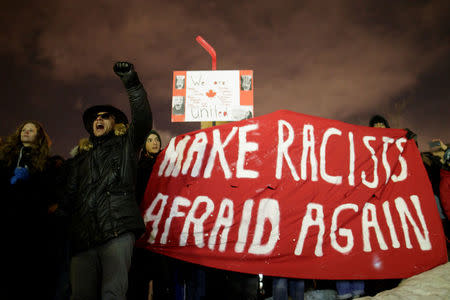 A man screams as people hold a sign during a vigil in support of the Muslim community in Montreal, Quebec, January 30, 2017. REUTERS/Dario Ayala