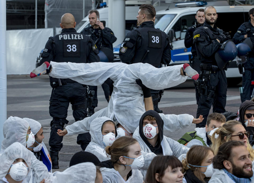 Activist perform as they block the main entrance of the fairground in Frankfurt, Germany, Sunday, Sept. 15, 2019. They protest against the government's transport policy on occasion of the IIA Auto Show taking place. (AP Photo/Michael Probst)