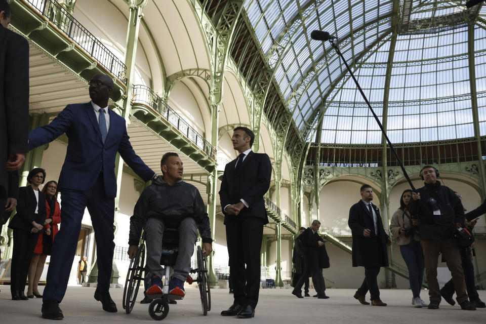 French. President Emmanuel Macron, center, visits the Grand Palais ahead of the Paris 2024 Olympic Games in Paris, Monday, April15, 2024. The Grand Palais will host the Fencing and Taekwondo competitions during the Paris 2024 Olympic Games. (Yoan Valat, Pool via AP)