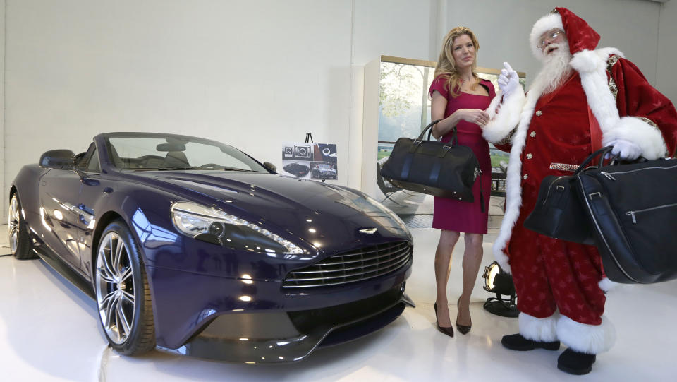 Actor Brady White, right, portrays Santa Claus as he and model Lesley Heaton show off the 2014 Aston Martin Vanquish Volante during the unveiling of the gifts included in the Neiman Marcus Christmas Book Tuesday, Oct. 8, 2013, in Dallas. The special edition Aston Martin is on sale for $344,5000 (AP Photo/LM Otero)