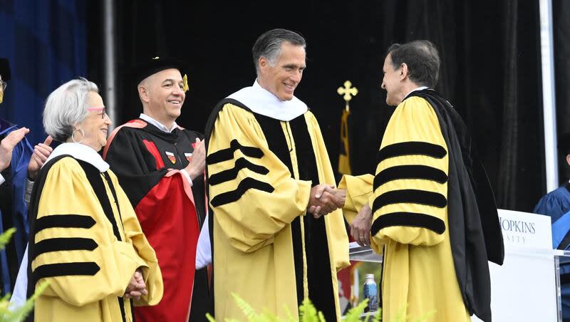 Sen. Mitt Romney, R-Utah, shakes hands with Johns Hopkins University President Ronald Daniels, Thursday, May 23, 2024. Romney was the university's commencement speaker.