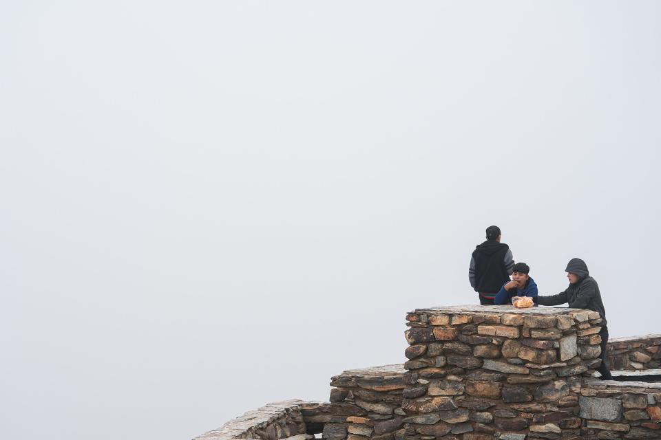 A trio of friends hand out and snack on an overcast at Dobbins Lookout on Dec. 4, 2022, in Phoenix.