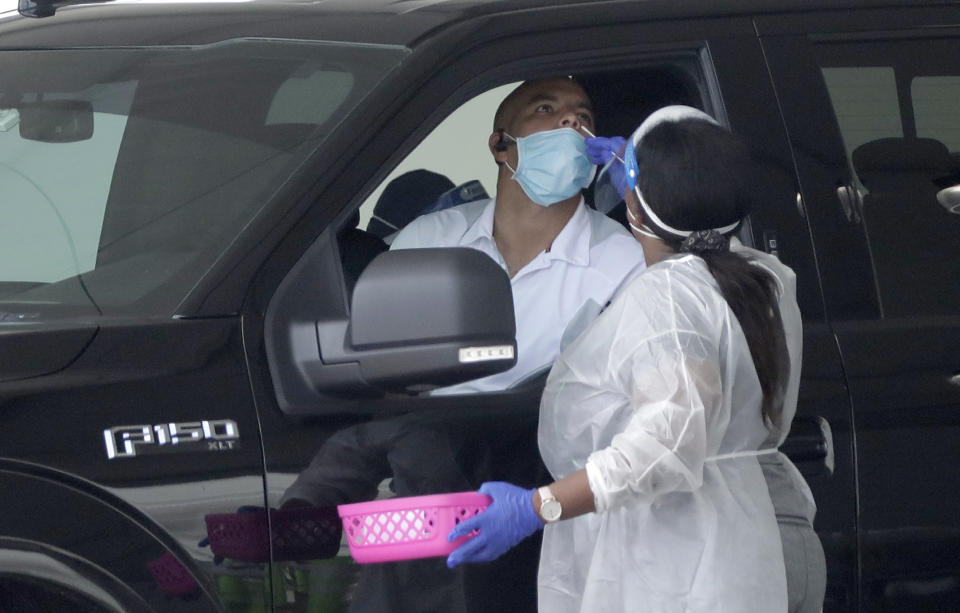 A healthcare worker performs an antigen test, Wednesday, Aug. 5, 2020, at a COVID-19 testing site outside Hard Rock Stadium in Miami Gardens, Fla. State officials say Florida has surpassed 500,000 coronavirus cases. Meanwhile, testing is ramping up following a temporary shutdown of some sites because of Tropical Storm Isaias. Antigen testing reveals whether a person is currently infected with COVID-19. It differs from antibody testing because once the infection is gone, antigens won't be present. (AP Photo/Wilfredo Lee)