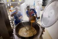 Cooks prepare for a school lunch as nutritionist Kazumi Sato looks on, inside the cookroom at Senju Aoba Junior High School in Tokyo