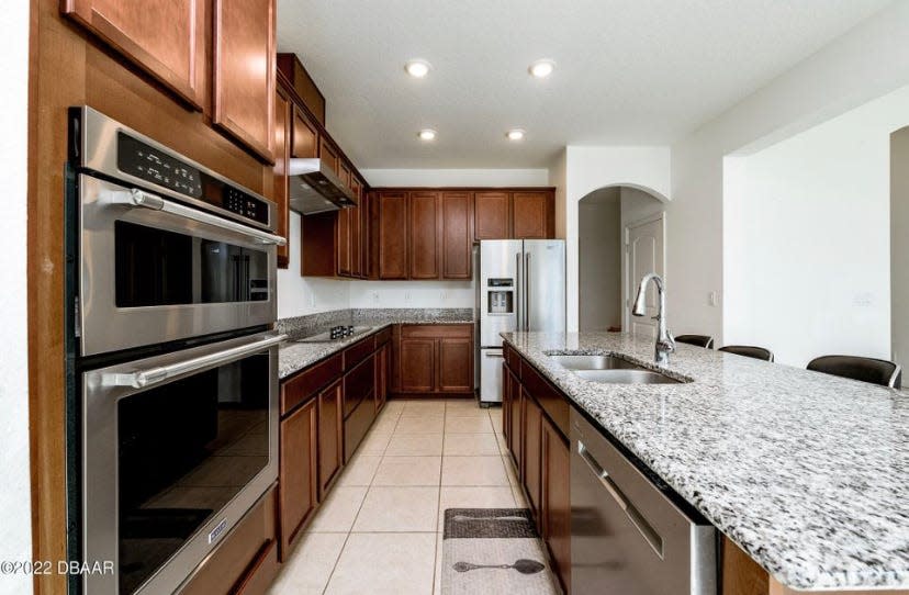 The ideally sized open kitchen is adorned with hardwood cabinetry, 42-inch uppers, soft-close doors and drawers, granite countertops, stainless-steel appliances.