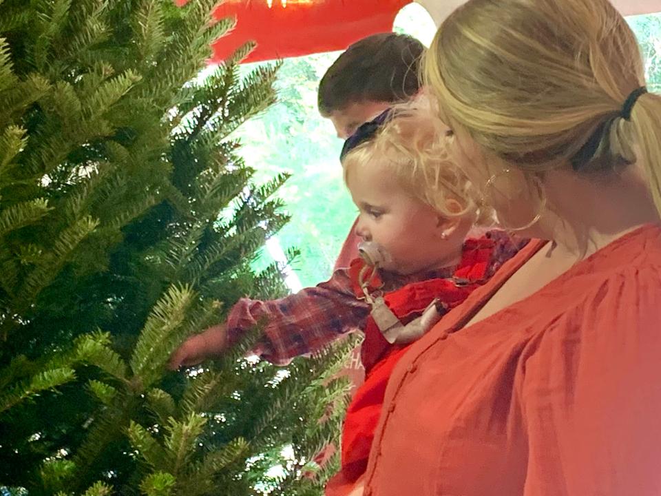 FILE - Little Harper Godbee, 16-months old, checks out one of the Christmas trees sold at the Buy A Tree. Change A Life lot at Oasis Church at Hephzibah on November 21, 2021. The annual campaign is back now until they run out of trees.