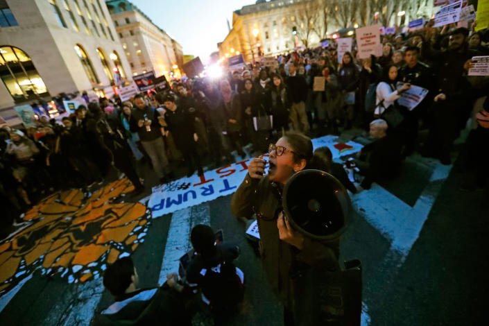 <p>Deyanira Aldama of Perth Amboy, N.J., uses a megaphone as others sit in 15th Street at Pennsylvania Avenue, near the White House, during a protest about President Donald Trump’s immigration policies, Wednesday, Jan. 25, 2017 in Washington. (AP Photo/Alex Brandon) </p>