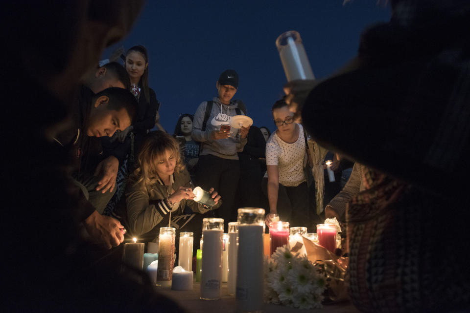 Mourners place candles and flowers on the ground during a candlelight vigil. (Photo: Martin S. Fuentes for HuffPost)