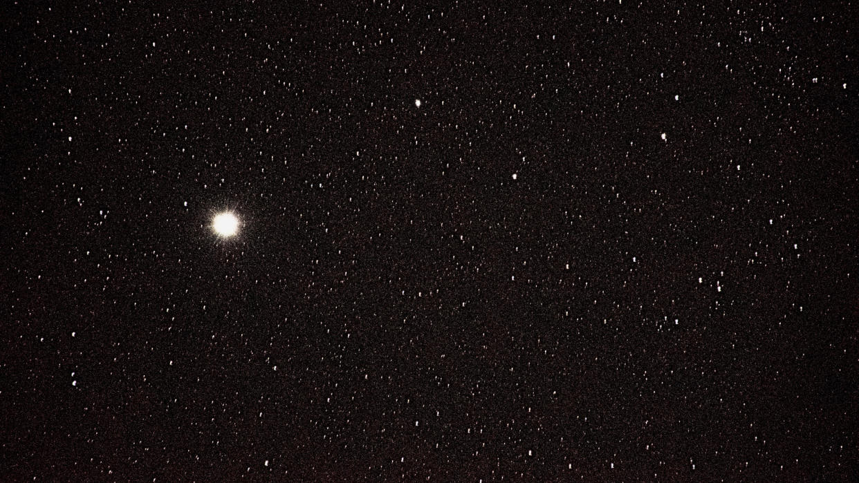  A vast array of stars in a black sky. on star, left of middle center is extra big and bright. 