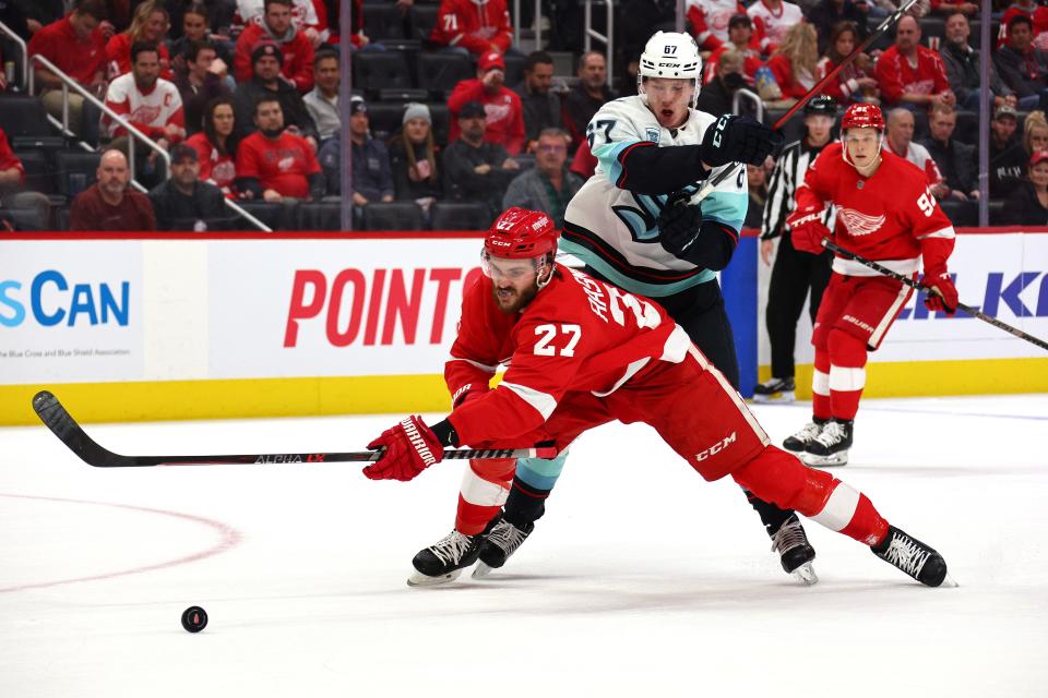 Michael Rasmussen (27) of the Detroit Red Wings battles for the puck against Morgan Geekie (67) of the Seattle Kraken during the first period at Little Caesars Arena on Dec. 1, 2021 in Detroit.